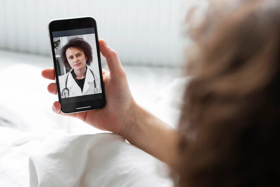 A woman on a video call with a healthcare professional on her phone